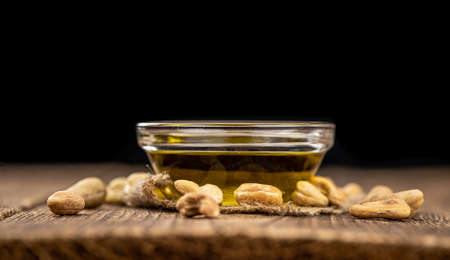 Fresh made Cashew Oil on an old wooden table (close-up shot; selective focus)の写真素材