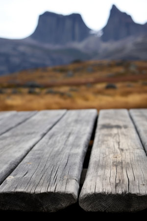 A blurry background of Cradle Mountain on a wooden table. Image generated with Generative AIの素材