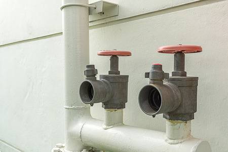 two fire hydrant on water pipe outside building close up shot