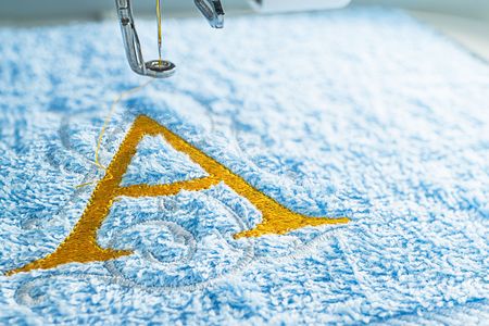 Close up picture of embroidery design yellow alphabet on towel embroider by machine, copy space on the right side.の写真素材