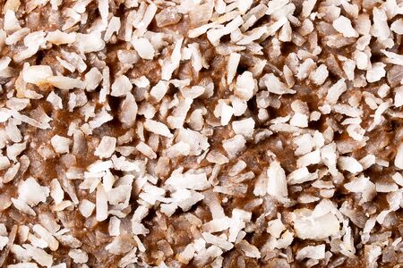 Surface of chocolate bar topping with coconut flakes macro picture