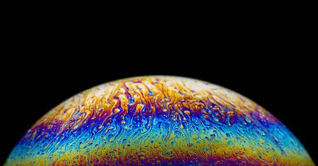 Close up picture of half soap bubble psychedelic color on blackground look like planet have liquid...