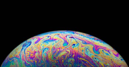 Close up picture of half soap bubble on blackground look like planet have liquid psychedelic color...