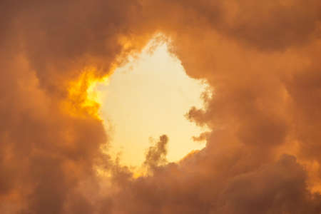 Hole in the fluffy golden clouds, abstract nature phenomenon backgroundの写真素材