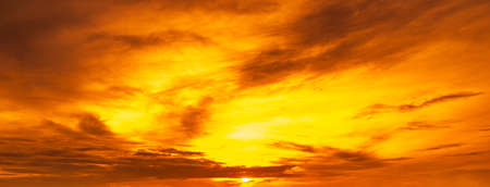 Golden sky with sun and clouds, panoramic background image.の写真素材