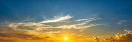 Panoramic view of the blue sky with shining yellow sunrise and clouds, nature wallpaperの写真素材