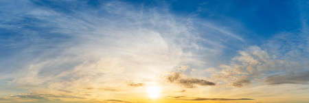 Bright yellow sunrise on cloudy blue sky panoramic view nature backgroundの写真素材