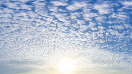 The brightness sun and fluffy Cirrocumulus clouds full on blue sky, nature phenomenon picture.の写真素材