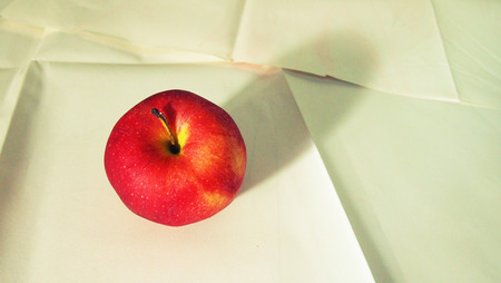 Red apple on white paperの写真素材