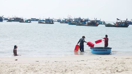 Fishermen on Vung Tau beach with boats in the backgroundのeditorial素材