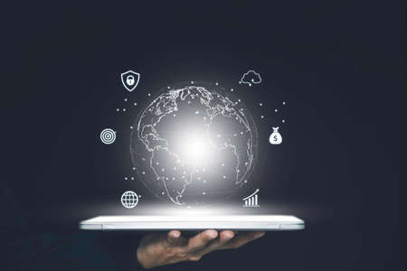 Man hand protecting virtual world on tablet with internet connection for metaverse.の写真素材