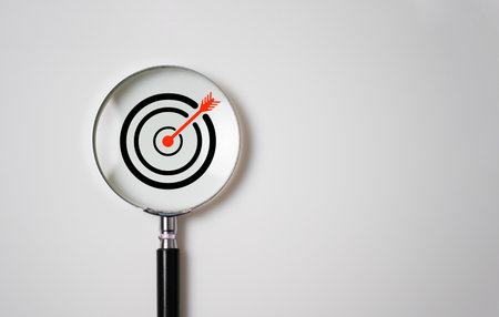 Target board inside of magnifier glass for focus business objective on white background and copy space.の写真素材
