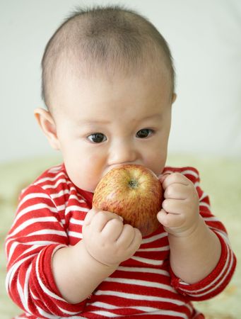 baby holding appleの写真素材