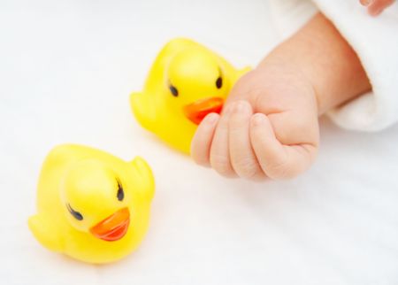 infant baby's hand and toy ducks.の写真素材