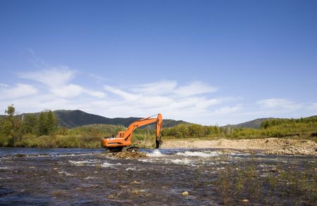 excavator dredging sediment mud from river の写真素材
