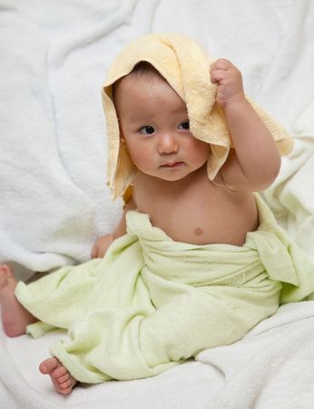 cute baby was wrapped by towels after bath.の写真素材