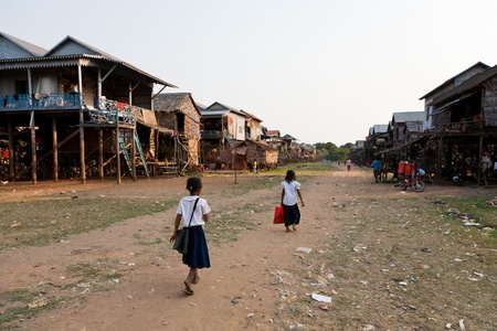 Kom Pong Pluke, Siem Reap, Cambodia - February 3, 2011: Two students wearing school uniforms are walking along the dirt road through village.のeditorial素材