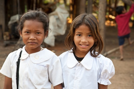 Kom Pong Pluke, Siem Reap, Cambodia - February 3, 2011:The portrait of two local smiling girl students wearing school uniforms. のeditorial素材