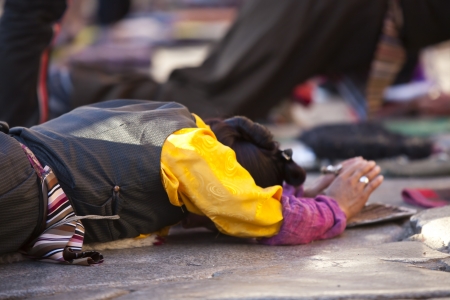 Lhasa, Tibet, China - 08 October, 2011: A female tibetan prayer is praying at Jokhang Temple. Lhasa, Tibet, China.のeditorial素材