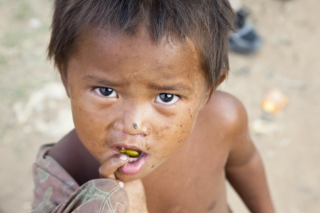 Kom Pong Pluke, Siem Reap, Cambodia - February 3, 2011: A little boy looking at camera, he is living at the village.This village is near Tonle Sap Lake. When rainy season come, the road will be submerged. Houses just like floating on water. The village alのeditorial素材
