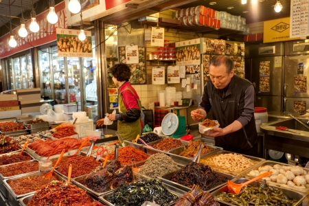 Seoul, South Korea - April 27, 2013: Vendors are selling kimchi at local market. Kimchi, the staple Korean food, is long-term fermented vegetables served as a side dish. the Gwangjang Market is the nationのeditorial素材