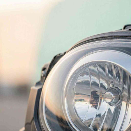 Close-up of a headlight of a car with a blurred background