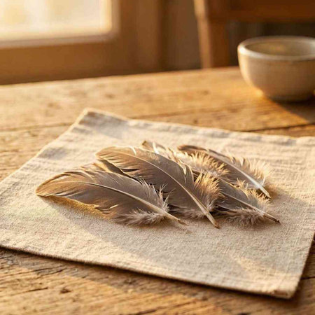 feathers on a napkin and a cup of coffee on a wooden table