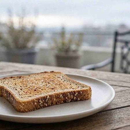 Sliced bread with sesame seeds on a wooden table.