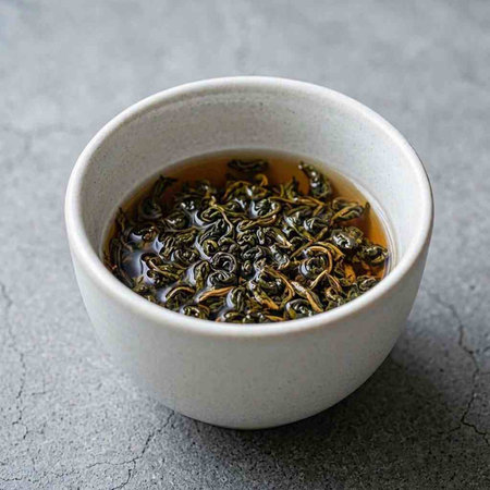 Green tea in a cup on a gray background. Close-up.