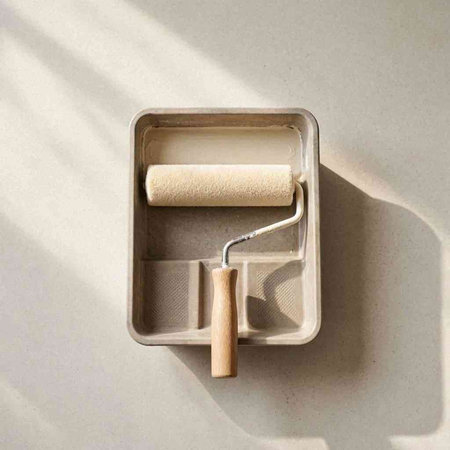 Paint roller in a box on a light background. Top view.