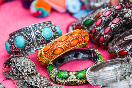 Focus your silver bracelet with jewelry and colorful background of many artifacts from Thailand.