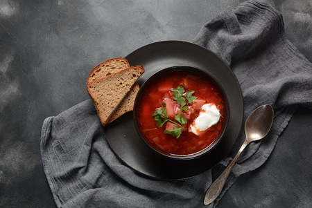 Traditional Ukrainian Russian borscht . Bowl of red beet root soup borsch with white cream on dark background. Beet Root delicious soup . Traditional Ukrain food cuisineの写真素材