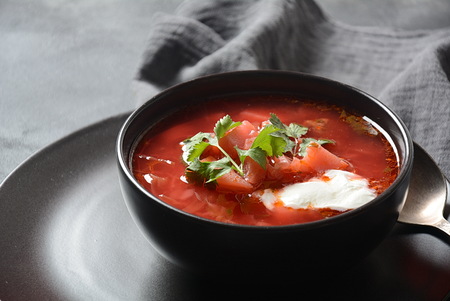 Traditional Ukrainian Russian borscht . Bowl of red beet root soup borsch with white cream on dark background. Beet Root delicious soup . Traditional Ukrain food cuisineの写真素材
