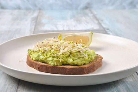 Healthy avocado sandwich , dark bread. Spicy rye toast