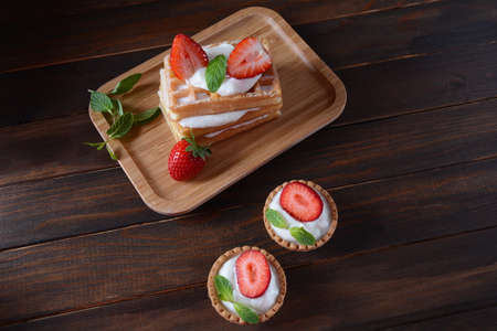 Belgian waffles with strawberries, whipped cream and mint leaves. Tasty dessert concept