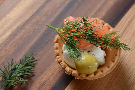 Tartalets with fresh salmon, philadelphia cream cheese, olives on wooden backgroundの写真素材