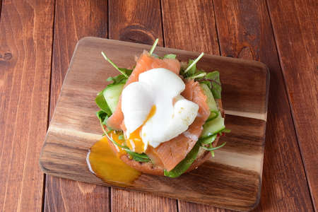 Poached egg with avocado, arugula beet leaves, black pepper on toast. Healthy breakfast concept