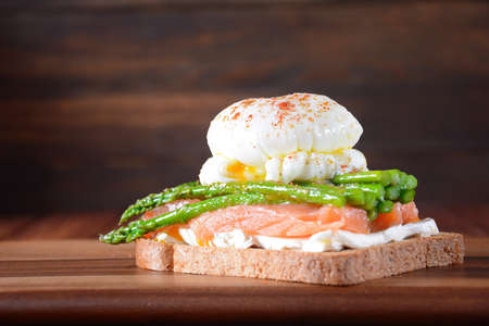 Poached egg with fried asparagus, cream cheese , salmon and spices on a toast. Healthy French breakfast conceptの写真素材