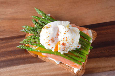 Poached egg with fried asparagus, cream cheese , salmon and spices on a toast. Healthy French breakfast conceptの写真素材
