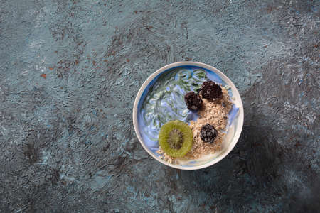 Blue and green spirulina fresh fruit smoothie bowl. Healthy breakfast concept