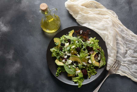 Avocado salad with   lettuce, blackberry, blue cheese, olive oil and arugula on a plate. Healthy...