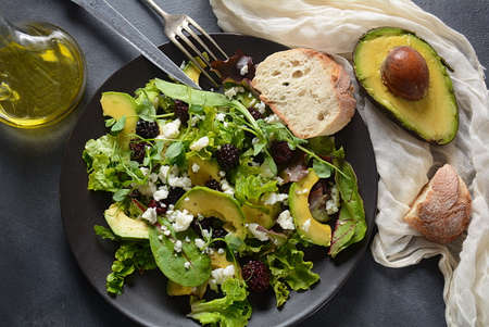 Avocado salad with   lettuce, blackberry, blue cheese, olive oil and arugula on a plate. Healthy vegan food conceptの写真素材