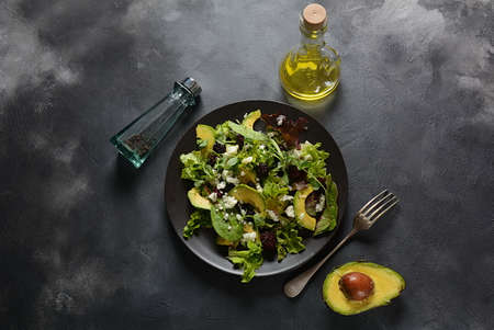 Avocado salad with   lettuce, blackberry, blue cheese, olive oil and arugula on a plate. Healthy...