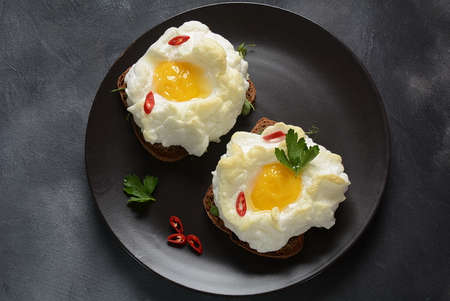 Delicate baked egg. Orsini eggs in the cloud. French breakfast.Cloud egg on toastの写真素材