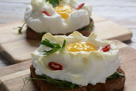 Delicate baked egg. Orsini eggs in the cloud. French breakfast.Cloud egg on toast