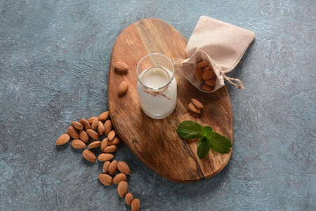 Almond milk in glass bottles with almonds on background. Vegan diary concept. Healthy food and...