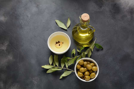 Extra virgin Olive oil , olive branch and olives on a dark backgroundの写真素材