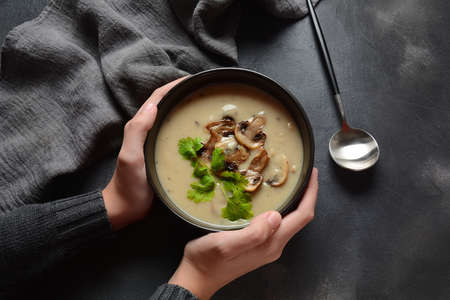 A bowl of Mushroom Cream Soup with fried champignons and fresh parsley. Winter, autumn hot soup conceptの写真素材