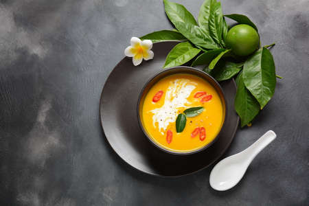 Thai spicy pumpkin and coconut milk soup with kaffir lime leaves , red chilli and galangal roots powder. Vegan, healthy food, gluten-free. Paleo- dietの写真素材