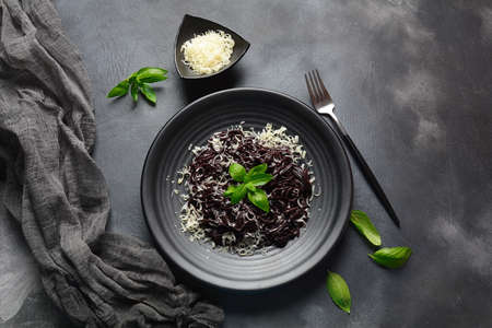 Squid Ink Pasta with , parmesan, basil leaves. Black spaghetti, black organic noodles . Mediterranean gourmet food.の写真素材